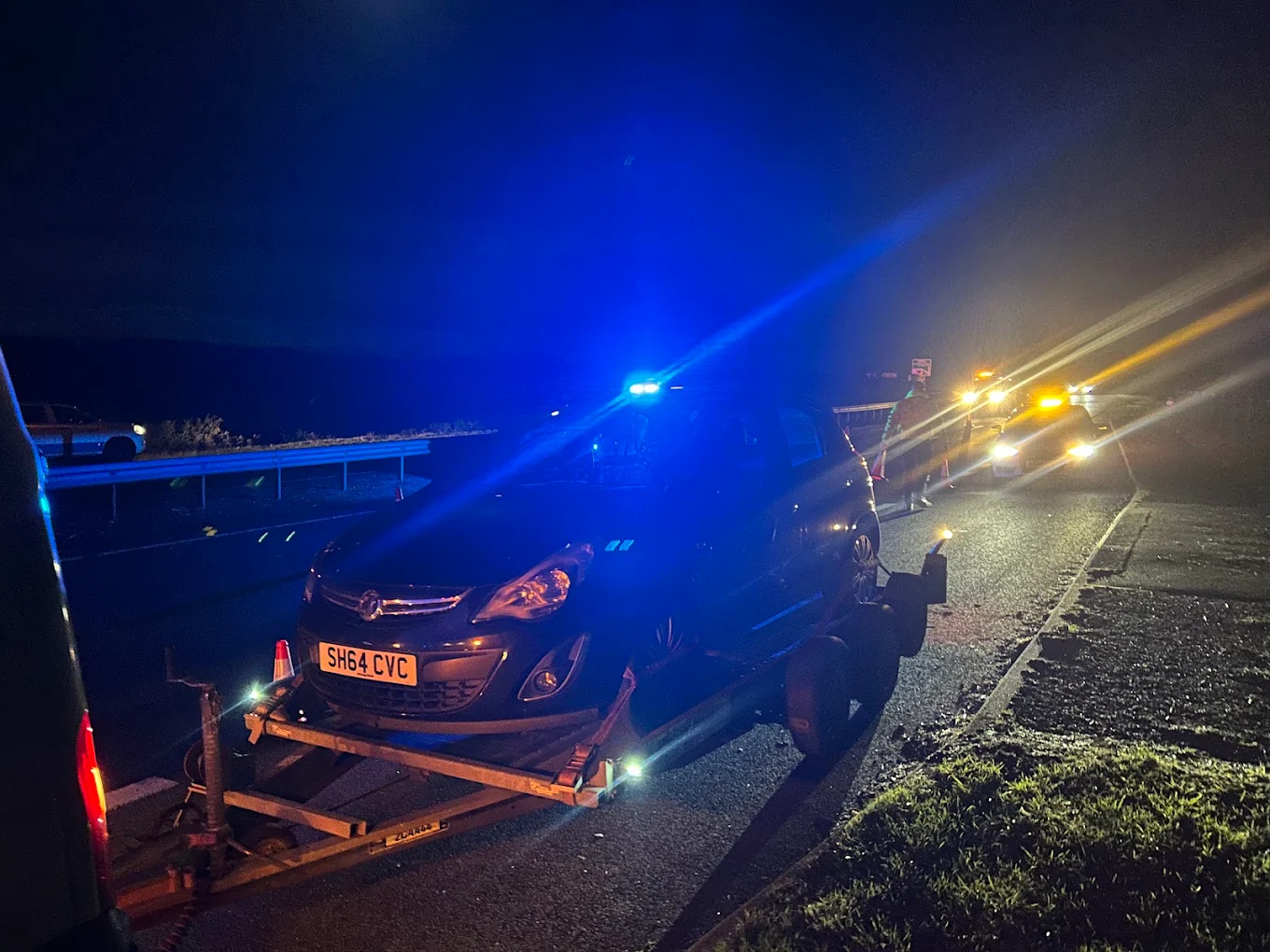 KJP recovery truck loading a vehicle at night